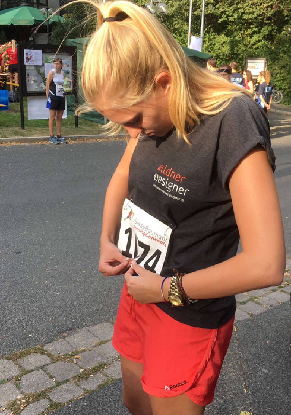 Vor dem Fürther Firmenlauf befestigt Viola ihre Startnummer am T-Shirt.