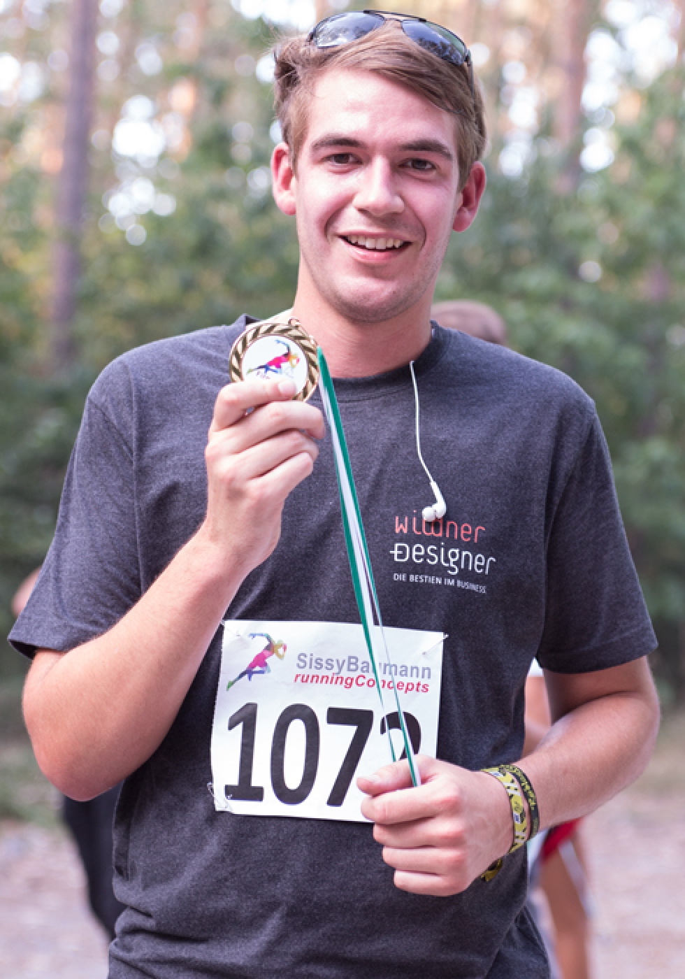 Julian erreiht das Ziel als erster des Wildner-Teams. Stolz hält er seine Medaille in der Hand.