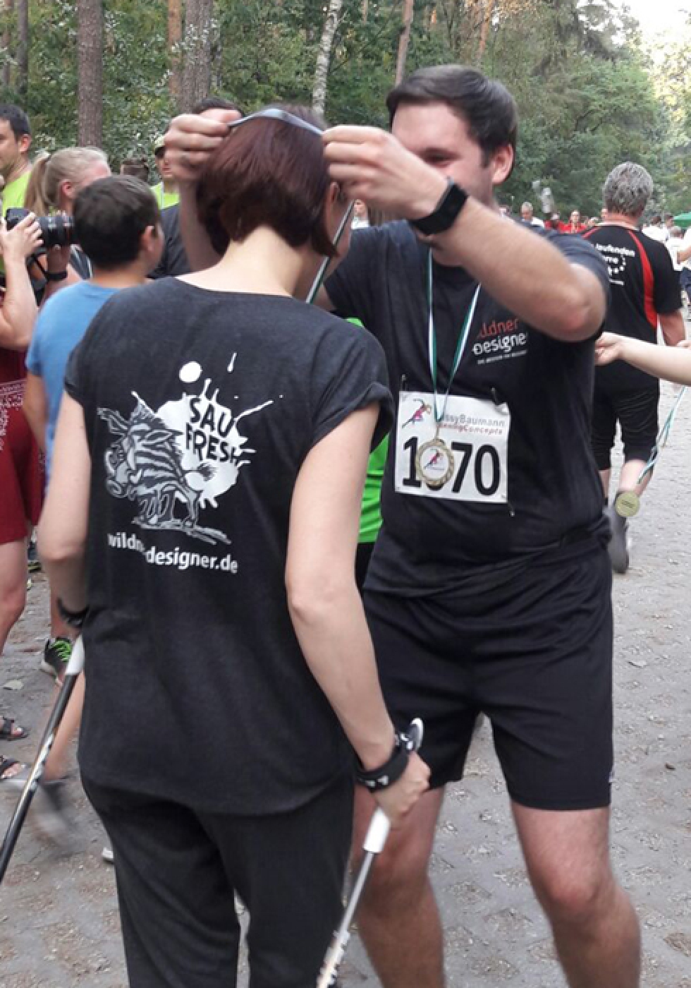 Andy überreicht Marina eine Medaille beim Fürther Firmenlauf.